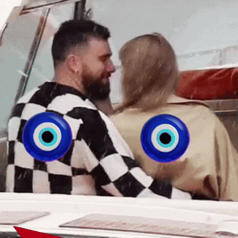 a man and a woman are sitting next to each other with evil eye symbols on their shirts