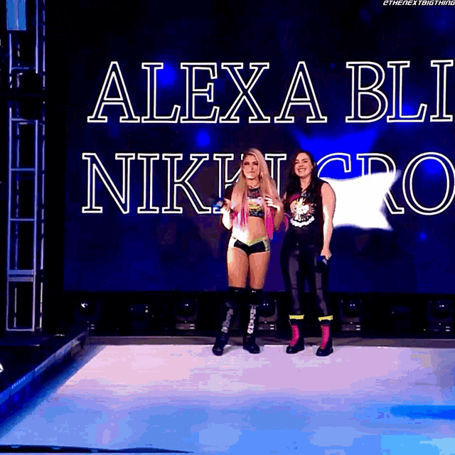 two women standing on a stage in front of a screen that says alexa bli nikki ro