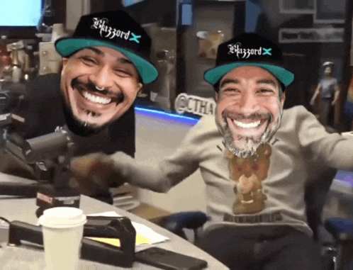 two men wearing hats with the word blizzard on them are smiling
