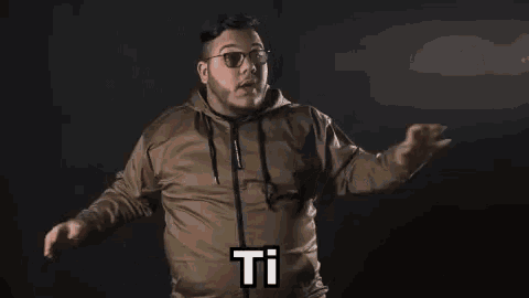 a man wearing glasses and a beard is making a funny face and saying `` ti piace il tuo ragazzo '' .