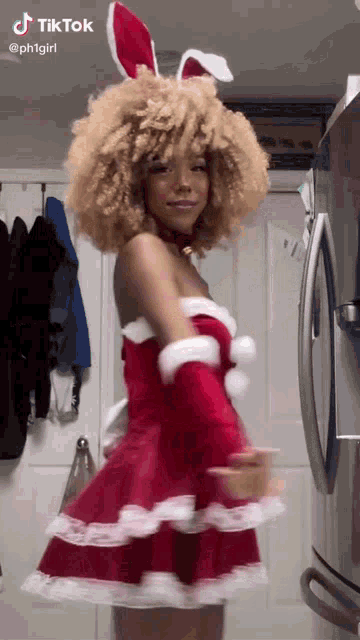 a woman in a santa costume with bunny ears