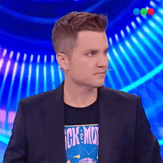 a man wearing a rick and morty shirt looks to his left
