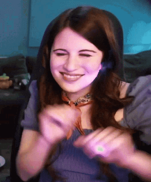 a woman wearing a purple shirt and a purple scarf smiles