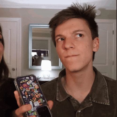 a man is holding a phone with a case that says ' spiderman ' on it