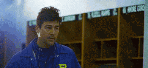 a man wearing a blue jacket with the letter p on the front