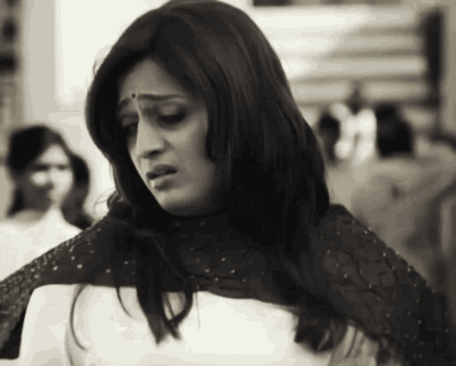 a woman with a bindi on her forehead looks sad