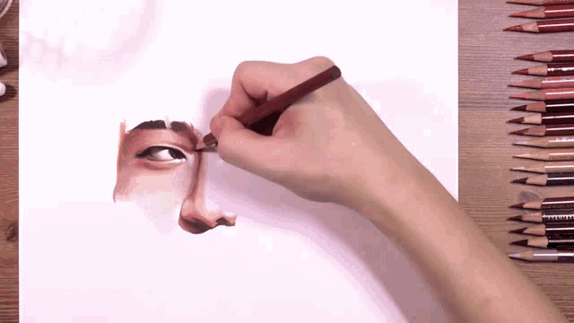 a person drawing a face with prismacolor pencils