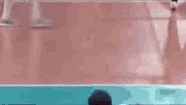 a man is standing on a volleyball court with his arms outstretched and his name on his back .