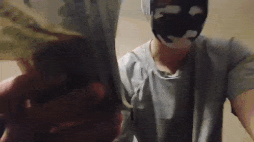 a man wearing a mask is holding a stack of money in his hand .