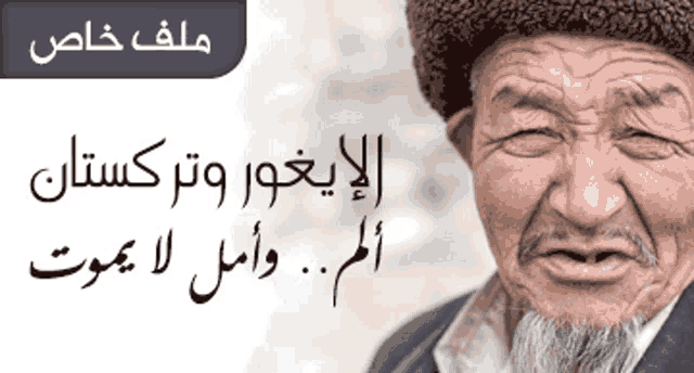 a man with a beard wearing a hat with arabic writing