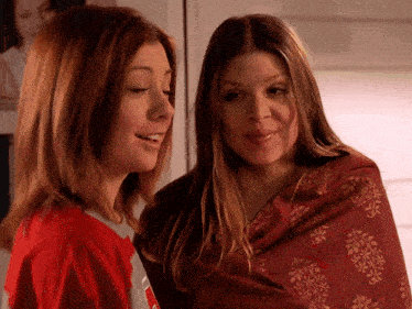 two women are standing next to each other and one is wearing a red shirt that says ' nebraska ' on it