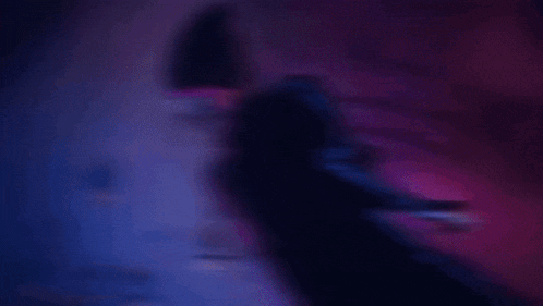a purple and blue animated character with a hat and a cape