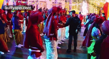 a man is shaking hands with a group of people in a crowd at a party .