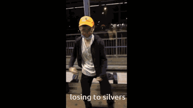 a man in a yellow hat is dancing with the words losing to silvers written below him