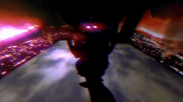 a person is standing in a dark room with a city in the background