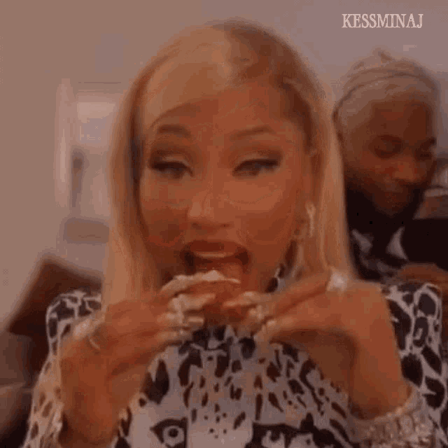 a woman is sitting on a couch eating a sandwich .