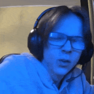 a man wearing glasses and headphones with a microphone .