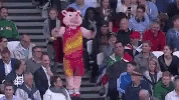 a mascot is standing in the middle of a crowd of people .
