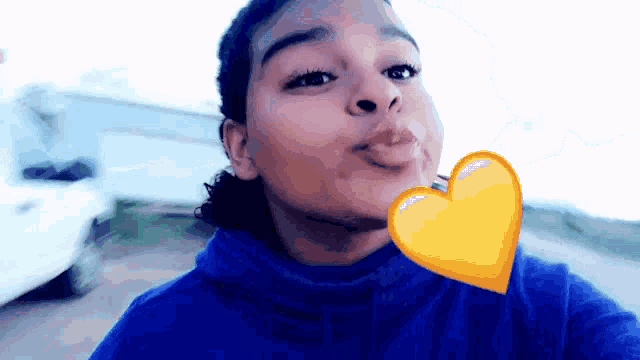 a young girl blowing a kiss with a yellow heart on her cheek