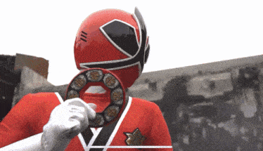 a red power ranger is holding a ring with chinese symbols