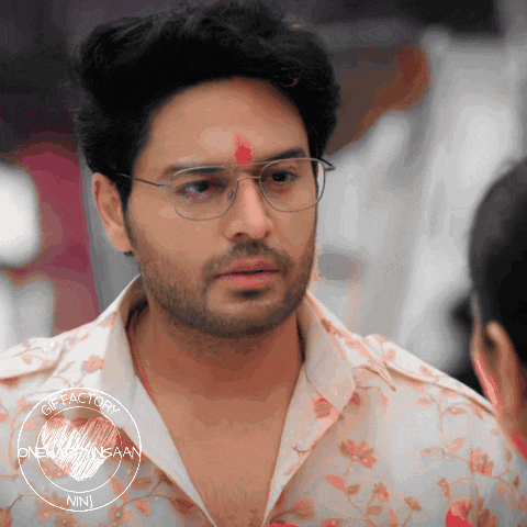 a man with glasses and a red dot on his forehead looks at another man