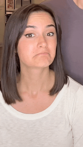a woman in a white shirt is making a silly face