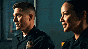a man and a woman are standing next to each other and the man has a patch on his uniform that says ' police '