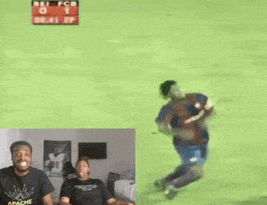 a man wearing an apache t-shirt is watching a soccer game