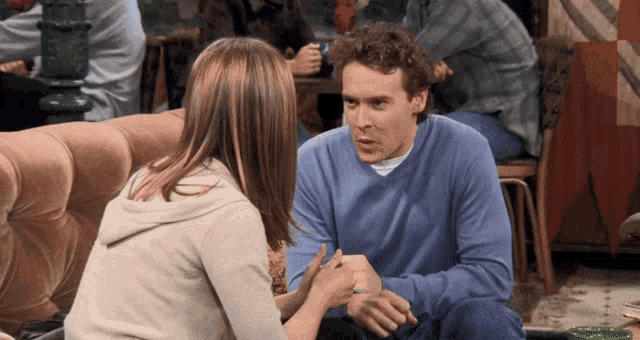 a man and a woman are sitting on a couch talking