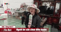 a woman in a hat is holding an ice cream cone in front of a tv screen ..