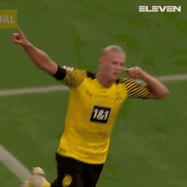 a soccer player in a yellow and black uniform is giving a thumbs up while standing on a field .