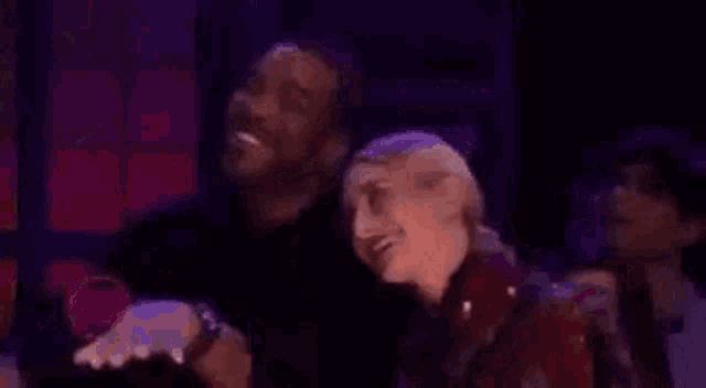 a man and woman are standing next to each other on a stage .