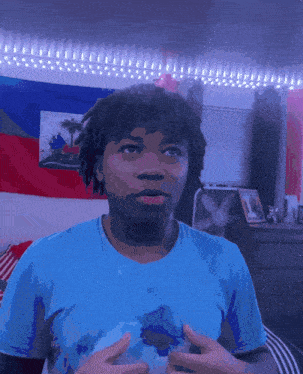 a man in a blue shirt stands in front of a haiti flag