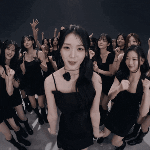 a girl in a black dress is surrounded by other girls