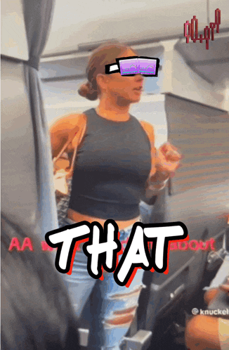a woman in a black tank top stands in front of a sign that says that on it