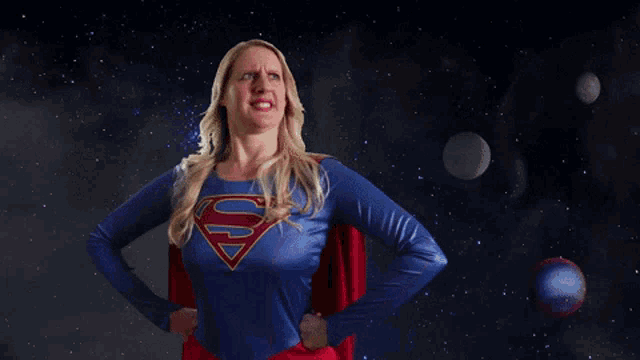 a woman in a superman costume is standing in front of a scarcity woman poster