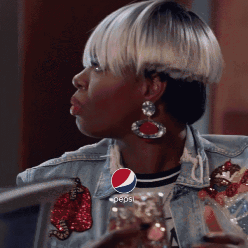 a woman wearing a denim jacket with a pepsi logo