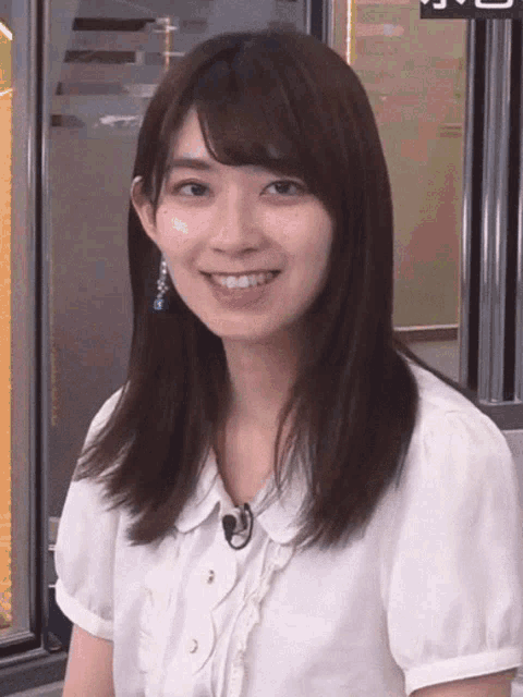 a woman in a white shirt with a microphone on her neck