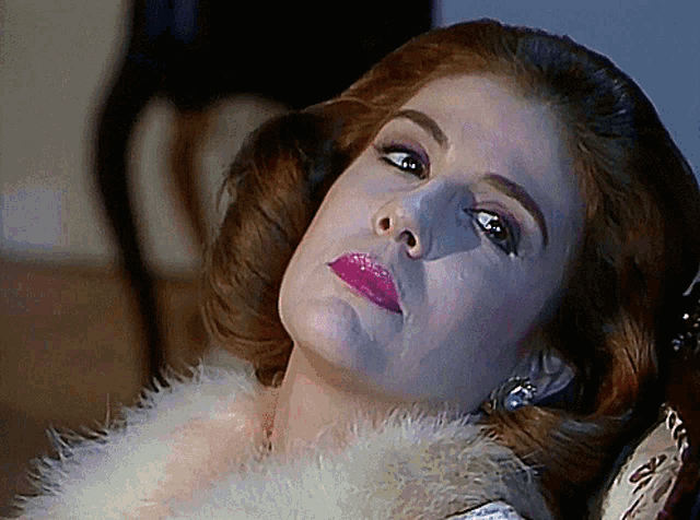a close up of a woman 's face with pink lipstick and a fur collar