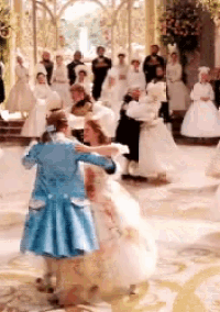 a woman in a white dress is dancing with a man in a blue jacket