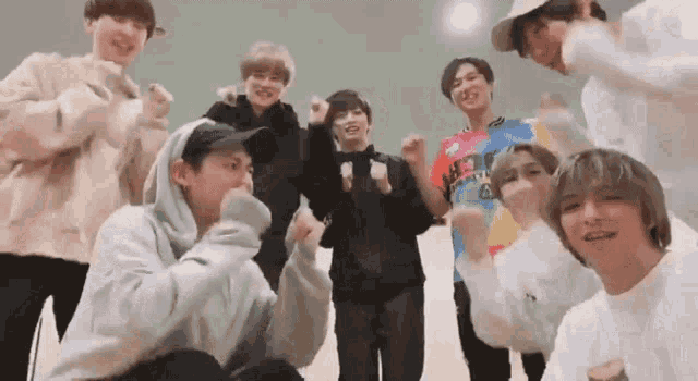 a group of young men are standing next to each other in a room and making funny faces .