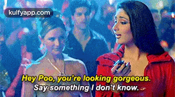 two women are standing next to each other and one of them is talking to the other .