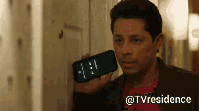 a man holding a cell phone in front of a door with the hashtag tvresidence