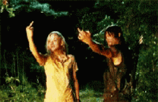 a man and a woman are dancing in the rain and the woman is giving the middle finger