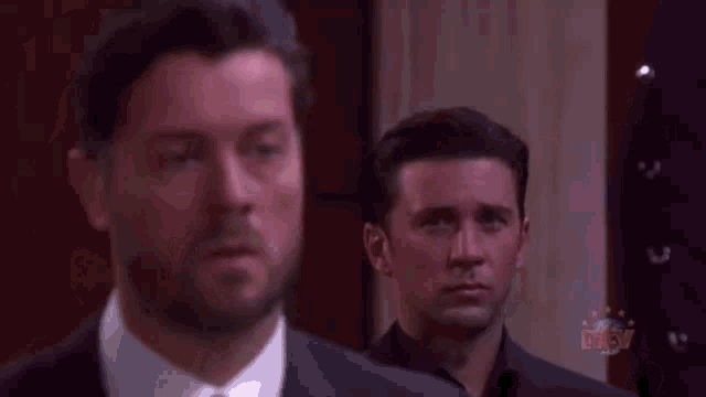 a man in a suit and tie stands next to another man with the words liar and traitor on the bottom right