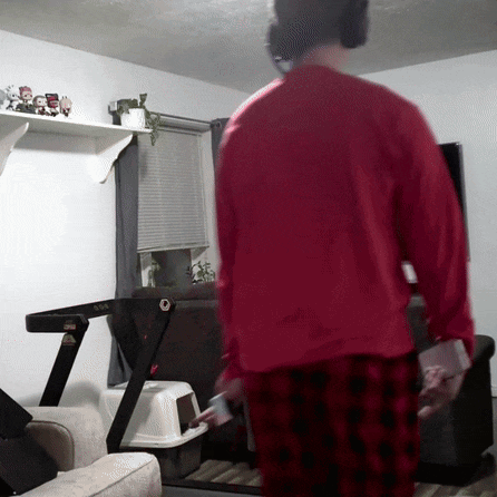 a man in a red sweater is walking on a treadmill