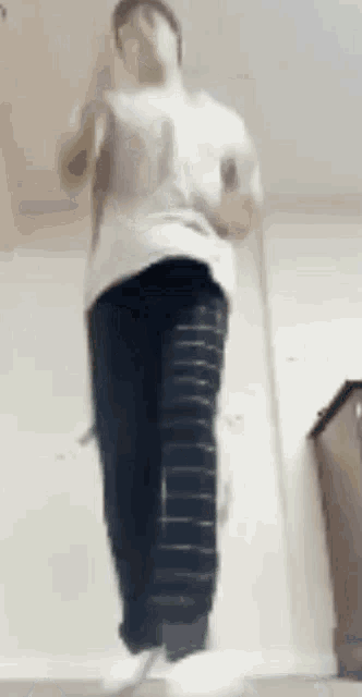 a person is jumping in the air while wearing striped pants and white socks .