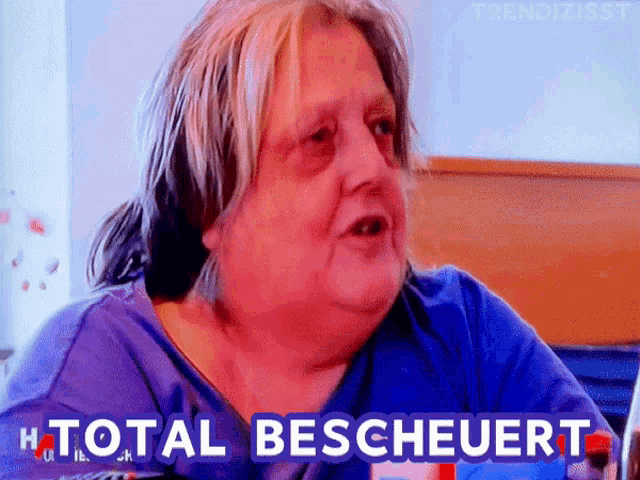 a woman in a blue shirt says " total bescheuert " in front of her face