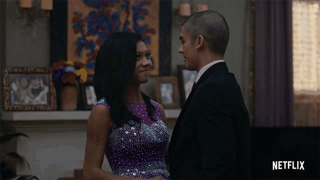 a woman in a purple dress is standing next to a man in a suit with netflix written on the bottom