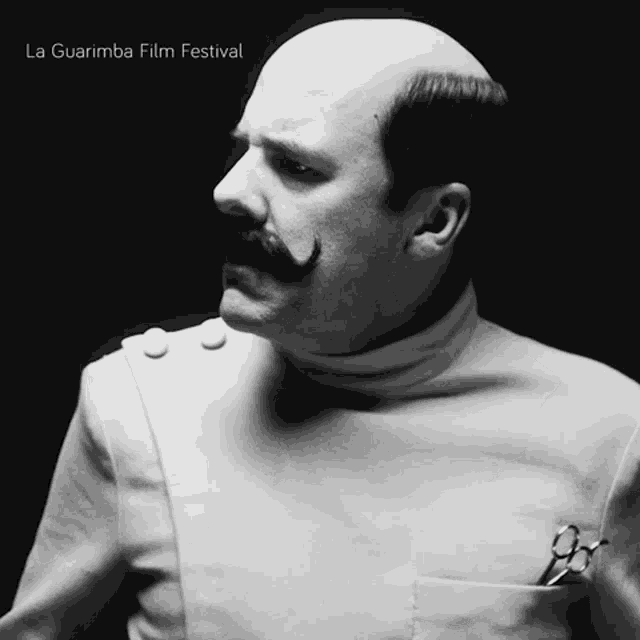 a black and white photo of a man with a mustache and scissors in his pocket sponsored by the la guarimba film festival